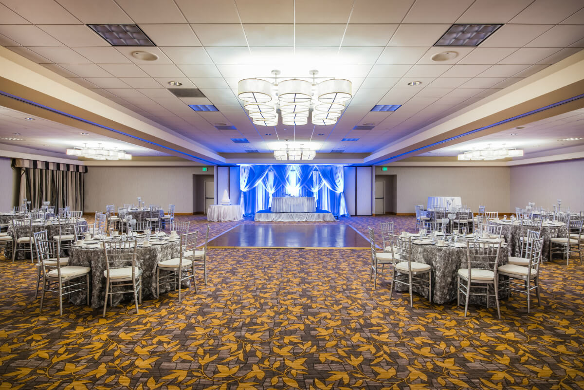 Wedding reception with dance floor, bridal party table, and guest tables at the Crowne Plaza San Francisco Airport.