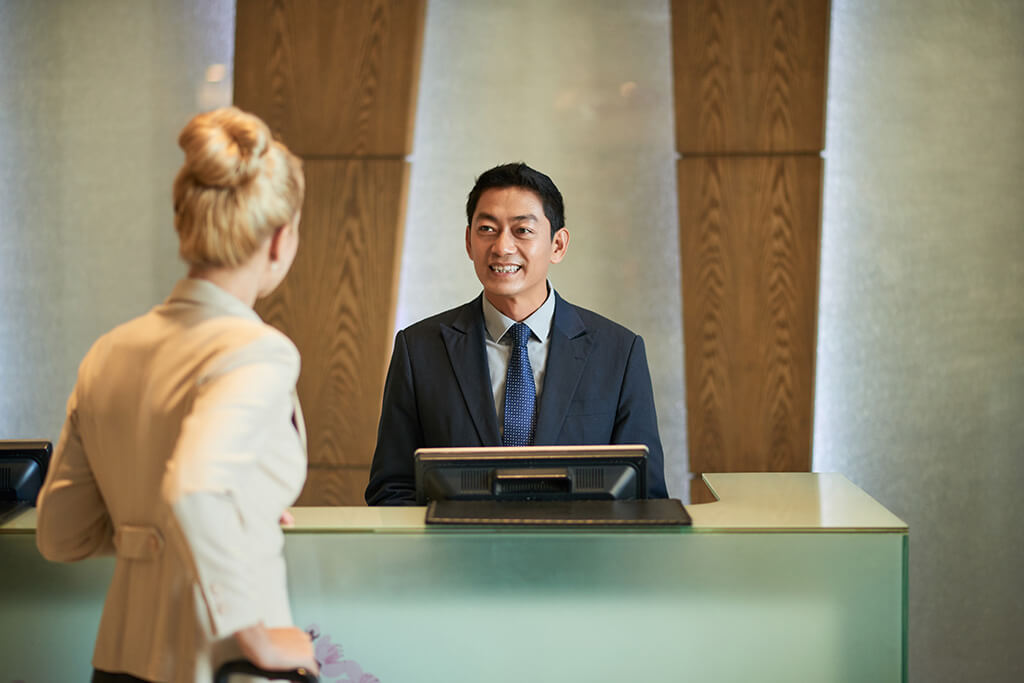 Business lady talking to receptionist of hotel
