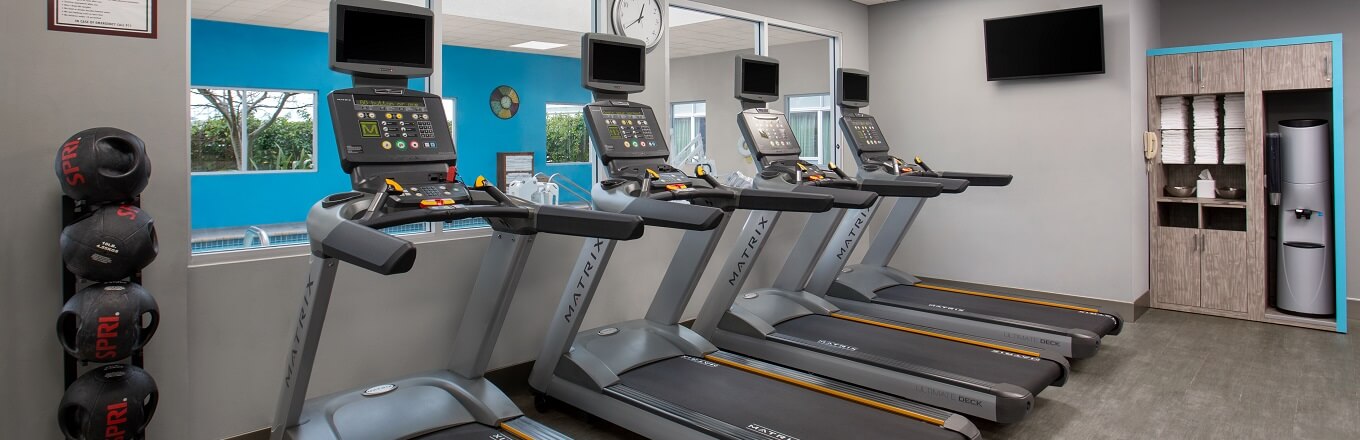 A row of treadmills overlooking the hotel pool.