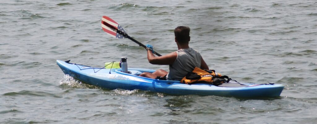 A man in a blue kayak in the water.
