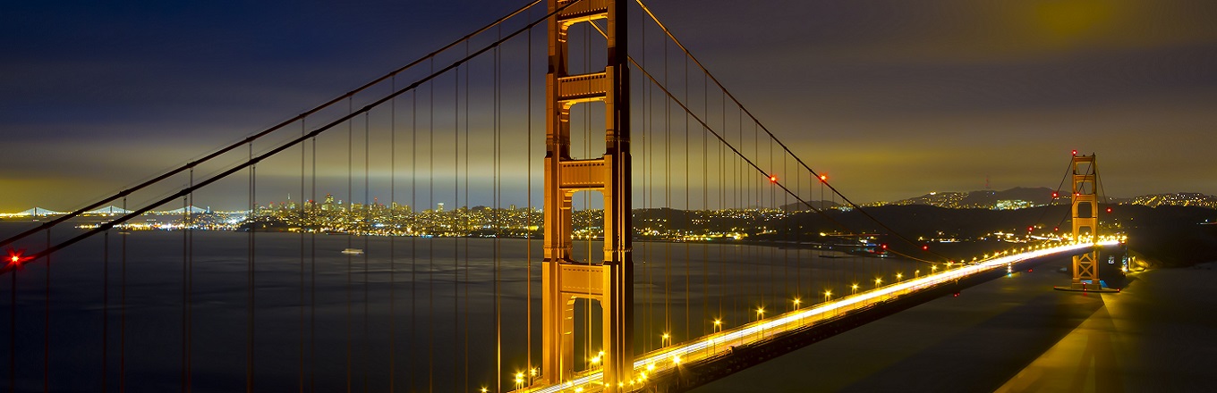 Close up of the Golden Gate Bridge and surrounding San Francisco Bay Area at night.