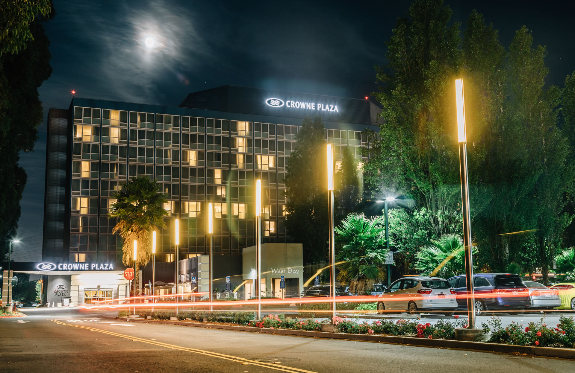 View of the Crowne Plaza San Francisco Airport hotel exterior at night.